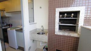 ボンビーニャスにある1007 Apartamento na Praia de Bombasのタイル壁にシンクがある小さなキッチン +33枚の写真