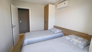 ボンビーニャスにある1007 Apartamento na Praia de Bombasのベッドルーム1室(ベッド2台付)、