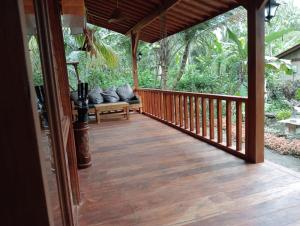 a wooden porch with a bench on a deck at Loka Amertha in Sidemen