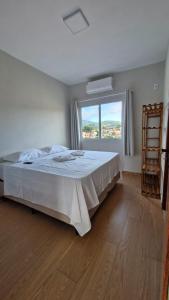 a bedroom with a large bed and a large window at Pousada Serra da Ferrugem in Conceição do Mato Dentro