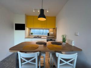 a kitchen with a wooden table and some chairs at Wonder Lelle - Balaton Retreat in Balatonlelle