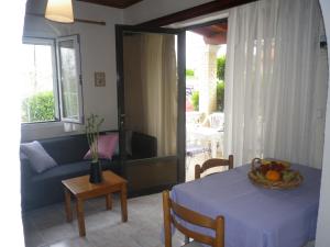 a living room with a table and a couch at Spiridoula apartments in Agios Stefanos