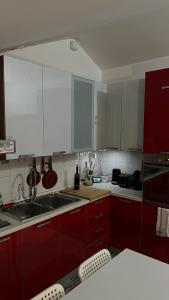 a kitchen with red cabinets and a sink at Spazio Oliveira Sparone in Sparone +27 photos
