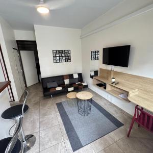 a living room with a couch and a flat screen tv at T2 en centre ville in Cayenne