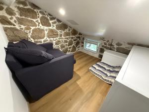 a living room with a couch and a stone wall at Casa Tassinca in Tasso