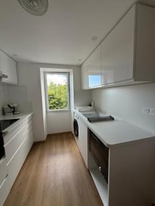 a kitchen with white cabinets and a sink and a window at Casa Tassinca in Tasso