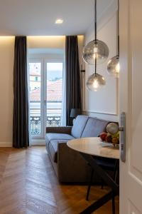 een woonkamer met een bank en een tafel bij Twins Boutique Apartments in Sanremo