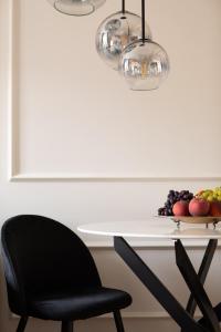 een tafel met een stoel en een fruitschaal bij Twins Boutique Apartments in Sanremo +67 foto's