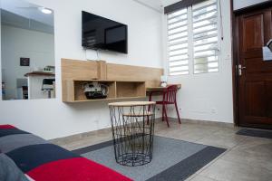 a living room with a table and a tv on a wall at T2 en centre ville in Cayenne