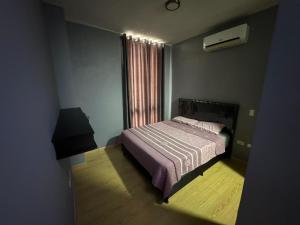 una piccola camera da letto con un letto e una finestra di Departamento amplio en el corazón de Santa Cruz a Santa Cruz de la Sierra