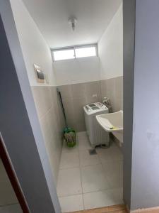 un bagno con un water, un lavandino e una finestra di Departamento amplio en el corazón de Santa Cruz a Santa Cruz de la Sierra