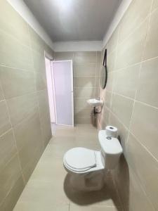 a bathroom with a white toilet and a door at Cabaña Palma Azul in Coveñas