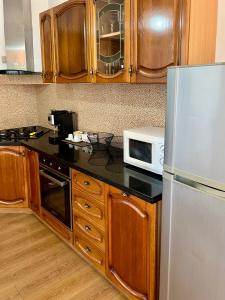 een keuken met een koelkast en een magnetron bij Beach Villa in Golem in Golem