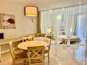 ein Wohnzimmer mit Tisch und ein Schlafzimmer in der Unterkunft Luxury Coastal Dreams Apartment in Sweti Wlas
