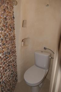 a bathroom with a toilet and a wall with logs at Holiday house with a parking space Senj - 24830 in Senj