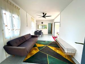 a living room with a couch and a ceiling fan at Homestay Kota Bharu Tok Paloh in Kota Bharu
