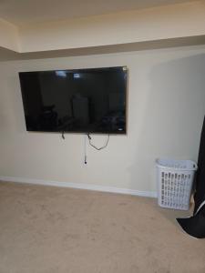 a flat screen tv hanging on a white wall at Mimis lodge in Brampton