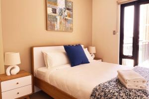 a bedroom with a bed with a blue pillow at Rooftops on HenryCentre of West End Cafes in Fremantle