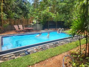 two people in a swimming pool in a yard at Rawana private cottage in Udawalawe
