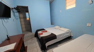 a small room with a bed and a television at Hotel Embaixador de Curitiba in Curitiba