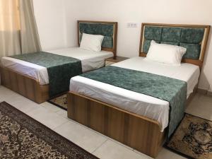 two beds in a small room with at شالية للايجار فى مراسي جريك in Sīdī ‘Abd ar Raḩmān