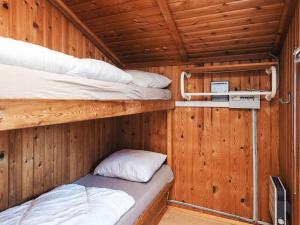 two bunk beds in a room with wooden walls at 4 person holiday home in Hampen in Hampen