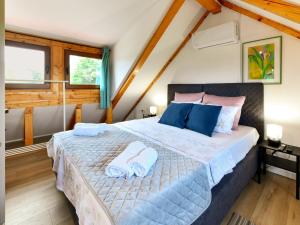 una camera da letto con un letto grande con asciugamani sopra di Plivanje u zalazak sunca - Three Bedroom House a Duga Resa