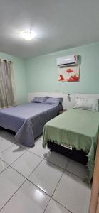 ein Schlafzimmer mit zwei Betten und einem Gemälde an der Wand in der Unterkunft Apartamento no Residencial Jardins das Thermas- Caldas Novas in Caldas Novas