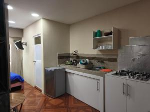 eine Küche mit weißen Schränken und einem Herd mit Backofen in der Unterkunft Mini Suite JyC in Manta