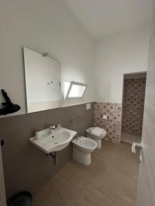 a bathroom with a sink and a toilet and a mirror at GioLì in Matino