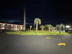 un aparcamiento nocturno con palmeras y un edificio en Lake Marion Inn, en Santee