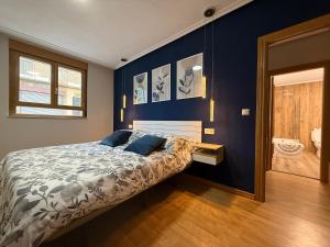 a bedroom with a bed and a blue wall at Cómodo apartamento a un paso del centro de Salamanca La Posada Charra 6 APART-37-278 in Salamanca +19 photos