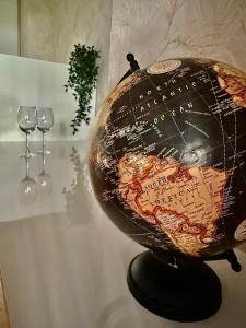 a globe on a table with two wine glasses at Cómodo apartamento a un paso del centro de Salamanca La Posada Charra 6 APART-37-278 in Salamanca