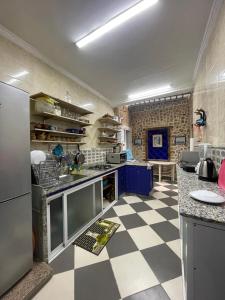 a kitchen with a black and white checkered floor at Family Vacation Beach House - Aouchtam in Aouchtame