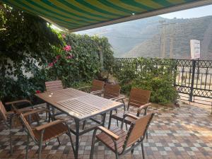 a wooden table and chairs on a patio at Family Vacation Beach House - Aouchtam in Aouchtame