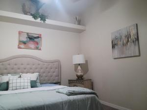 een slaapkamer met een bed en een lamp bij Cozy room with HEATED POOL & SPA -HOT TUB for relaxation in Valrico +11 foto's