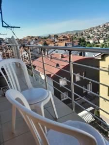 un balcon avec deux chaises et une vue sur une ville dans l'établissement Second Sweet Home, à Pristina