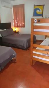 a bedroom with two beds and a ladder at Atlakamani Surf in Chirilagua