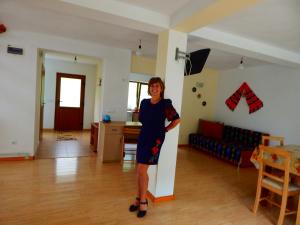 a woman is standing in a living room at Casa Silvia in Gîrda de Sus