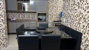 a kitchen with a table and some chairs and a counter at Casa Aconchegante de Praia in Caraguatatuba +5 photos