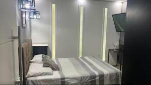 a small bedroom with a bed and a television at Casa Aconchegante de Praia in Caraguatatuba