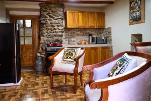 a kitchen with two chairs and a stove at Rumi Wasi Inn Ollantaytambo in Ollantaytambo