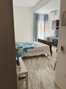 una camera da letto con un letto e un pavimento in marmo di Blu Gargano Apartment a Manfredonia