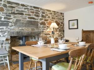une salle à manger avec une table et un mur en pierre dans l'établissement Seaton Cottage, à Collieston