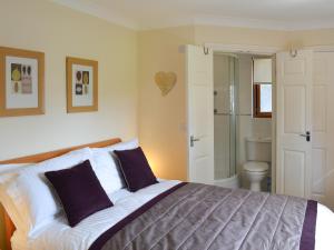a bedroom with a large bed and a bathroom at Pine Lodge in Sewerby