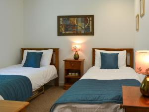 a bedroom with two beds with blue and white sheets at Pine Lodge in Sewerby +4 photos