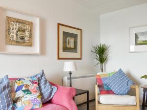 un salon avec un canapé rose et une chaise dans l'établissement Seaton Cottage, à Collieston