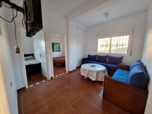 a living room with a blue couch and a table at Villa Diki beach in Ksar es Sghir