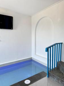a room with a blue floor and a flat screen tv at Calosa Villa in Batu