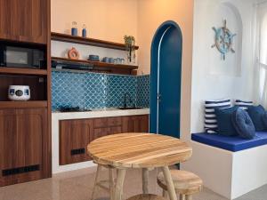 a kitchen with a wooden table and a blue stool at Calosa Villa in Batu